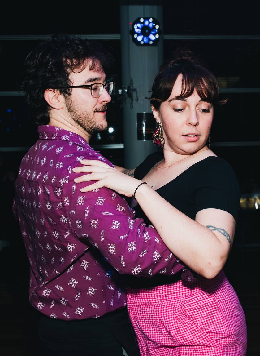 A couple dancing cheek to cheek in a close hold on the social floor